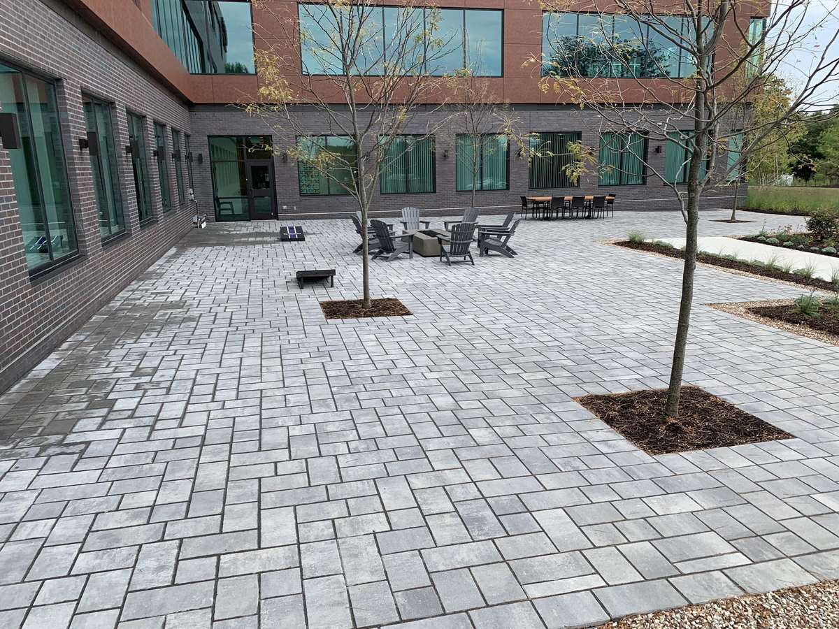 Large paver courtyard with tree wells outside a commercial office building