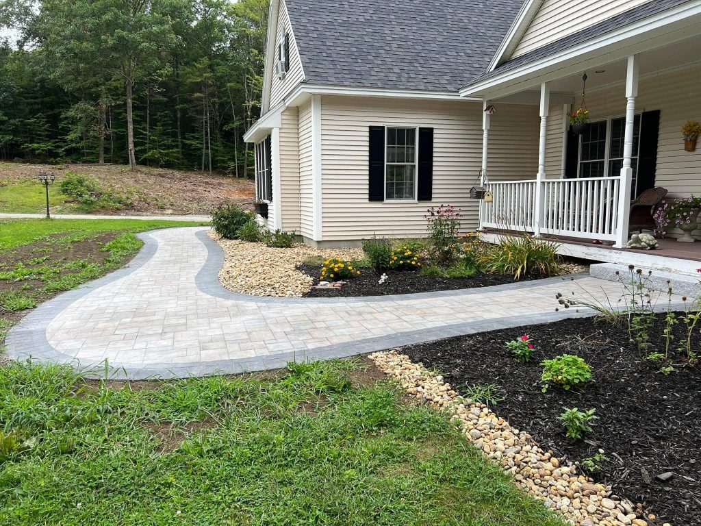 Curving paver walkway leading to the front porch of a home in Newfields, NH